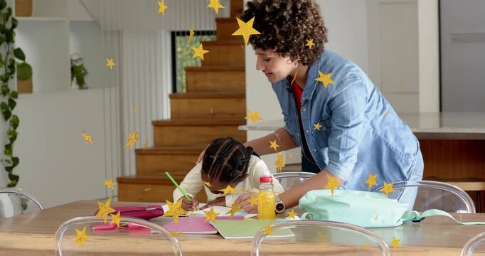 Child writing homework at table, woman placing hand guiding with green pencil, stars appearing
