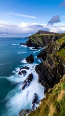 Obraz premium Coastal landscape with cliffs, ocean, waves, and sky on a bright day