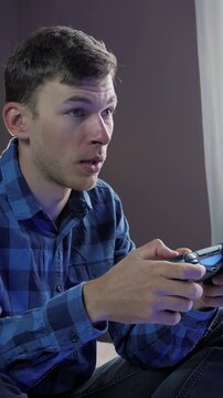 Man holding joystick and clicking on buttons, playing video game. Vertical video