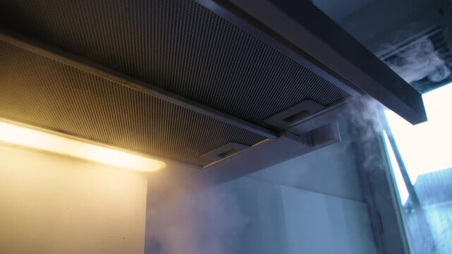 Kitchen Extractor Hood Removing Steam Above Stove in Modern Apartment Interior Highlighting Ventilation System and Functional Home Design Detail