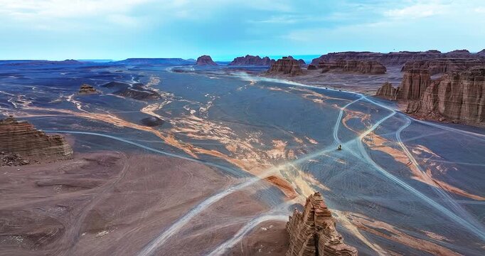 Aerial view of the vast gobi desert landscape with gravel plains and rock formations in Xinjiang, China.