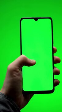 Green Screen man s hand holding a black smartphone with and touching or press display using mobile phone chroma key touch on background scene 3 distortion, overlay, glitch, static noise, scan lines