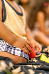 Child's hand holding toy during family picnic
