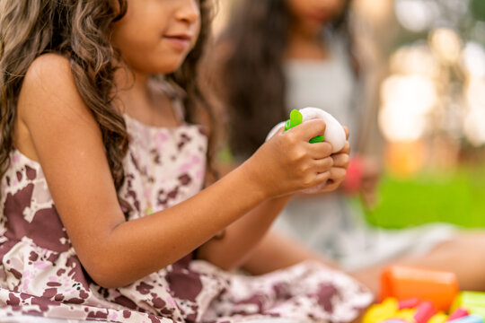 Young girl playing with squishy toy in park