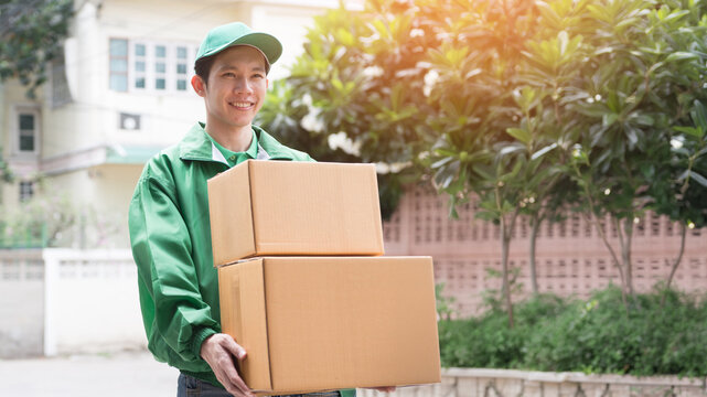 A professional delivery courier in uniform handing a package to a customer at the front door of a home.