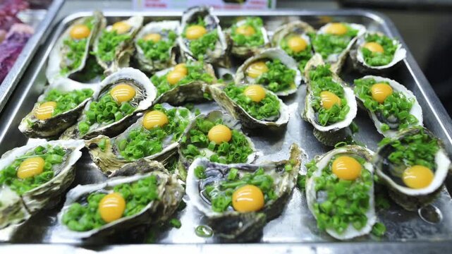 Tray Oysters With Quail Yolks And Scallion Glistening On Metal Tray At Vietnamese Street Market Stall Ready For Grill, Bright Yellow Yolks Contrasting Green Onions, Shells Arranged In Rows,
