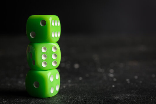 Green dices on dark background