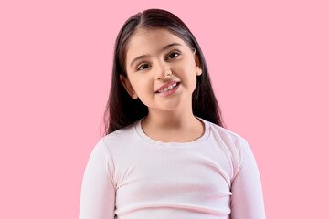 Little girl smiling on pink background, closeup