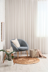Interior of living room with wicker carpet, armchair and table