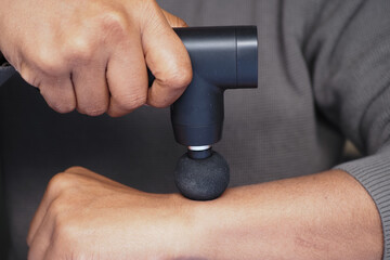 Hand-held device applied to arm for muscle relaxation © Towfiqu Barbhuiya 