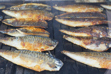 Grilled fish being cooked on a barbecue grill outdoors
