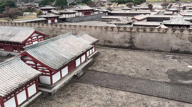 Old battlement of an ancient castle city wall in China, showing weathered stone crenellations with a blurred pathway and cloudy sky in the background, highlighting historical architecture and defensiv