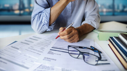 close up shot, asian businessman working on desk reviewing documents, financial reports and...