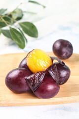Fototapeta premium Fresh Sweet Prunes from Chile Australia Imported Dried Plums on Wooden Board