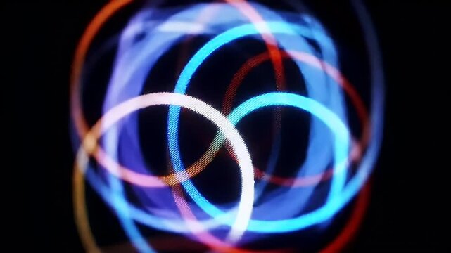 Abstract image featuring colorful rings intersecting in center on a dark background