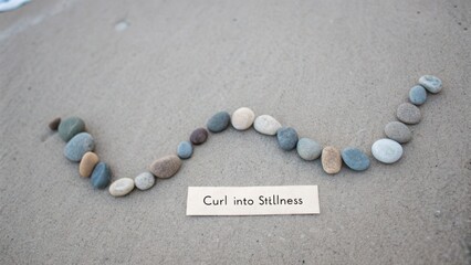Creative Arrangement of Smooth Stones on Sandy Surface with Inspirational Text Curl into Stillness