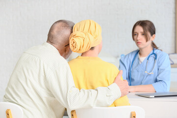 Obraz premium Mature woman after chemotherapy with her husband hugging in clinic, back view