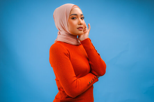 Elegant young Asian Muslim woman wearing veil hijab with make up posing and looking to the camera.