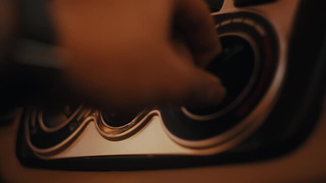 close-up of a hand adjusting the circular air conditioning or ventilation control dial on a car dashboard during a road trip or commuting