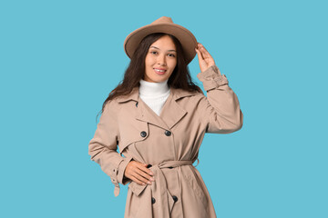 Fototapeta premium Beautiful young Asian woman in stylish hat on blue background