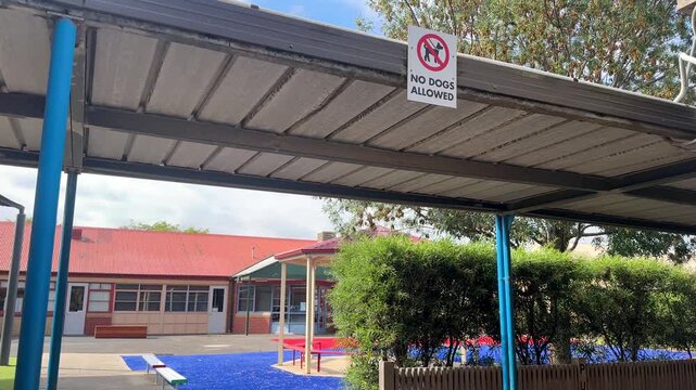&ldquo;No dogs allowed&rdquo; sign mounted under a covered walkway in a public primary school campus in Australia. The sign indicates school safety rules and restricted access for pets within the school grounds.