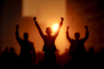 Fototapeta premium Joyful silhouettes dancing freely beneath a vivid setting sun.