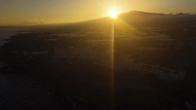 Aerial view rotating in front of hotels on the shore of south Jeju island, sunset
