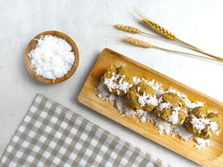 Traditional Indonesian Apem Cake With Palm Sugar and Grated Coconut in Wooden Plate