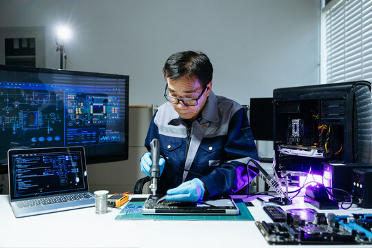 Technician performing PCB soldering and diagnostics with multimeter in electronics lab, showcasing hardware engineering