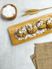 Traditional Indonesian Apem Cake With Palm Sugar and Grated Coconut in Wooden Plate