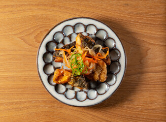 Top-down view of deep-fried mackerel marinated in sweet and sour vinegar sauce with vegetables,...