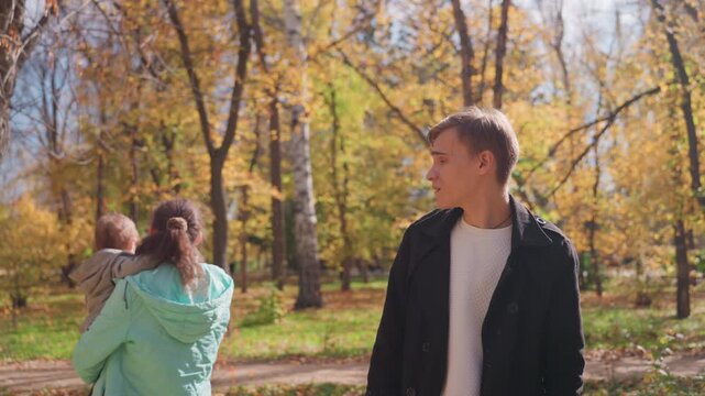Mother hugs child. Mother gently holds her child amidst fall scenery and peaceful surroundings. Caring mother lovingly embraces her young child surrounded by autumn leaves and tranquil environment