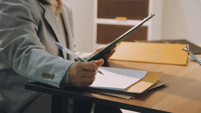 Justice and law concept. Gavel on sounding block in hand's Male judge at a courtroom, working with document law books, report the case on table in modern office.