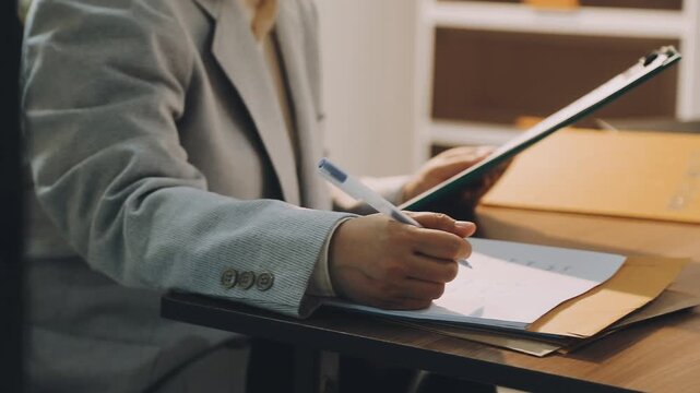 Justice and law concept. Gavel on sounding block in hand's Male judge at a courtroom, working with document law books, report the case on table in modern office.