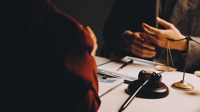 Justice and law concept. Gavel on sounding block in hand's Male judge at a courtroom, working with document law books, report the case on table in modern office.