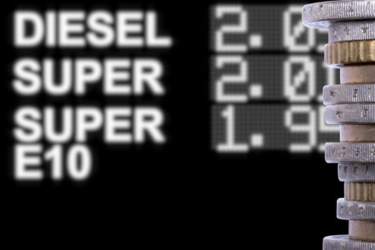 Euro M&uuml;nzen und Preistafel an einer Tankstelle, die hohe Kraftstoffpreise anzeigt