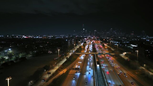 Aerial view of Dan Ryan Expressway traffic at night with Chicago skyline background