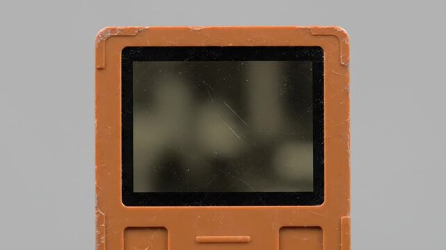 Orange Portable Game Console with Blurred Screen.