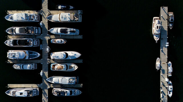 Top down drone photo of yachts and boats docked in marina with copy space