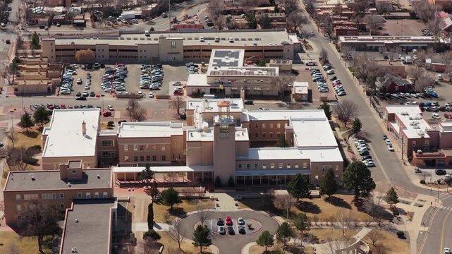 A smooth aerial retreat showcases the Zia-inspired design of the Roundhouse. The high-angle perspective captures the grand scale of the capitol grounds and the high-desert horizon.