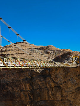 The yellow Chicham suspension bridge connecting rocky cliffs in the high altitude Himalayas.