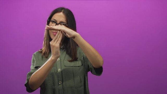 Young hispanic brunette woman making timeout gesture with hands in purple studio; boundary setting defiance.