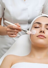 Professional Aesthetician Applying Pink Facial Cream to Relaxed Woman in a Bright Beauty Spa Room