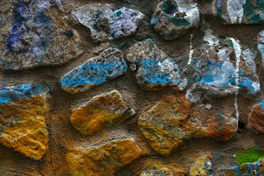 a stone wall painted yellow and blue