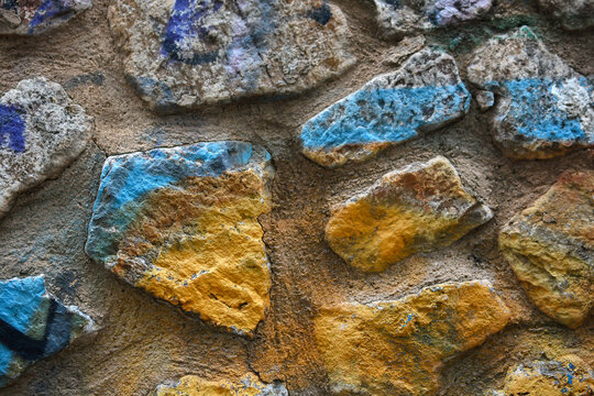 a stone wall painted yellow and blue