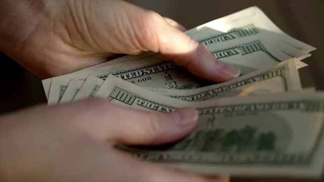 Close up of hands counting us dollar bills cash money transaction financial concept banking payment business economy wealth and income theme