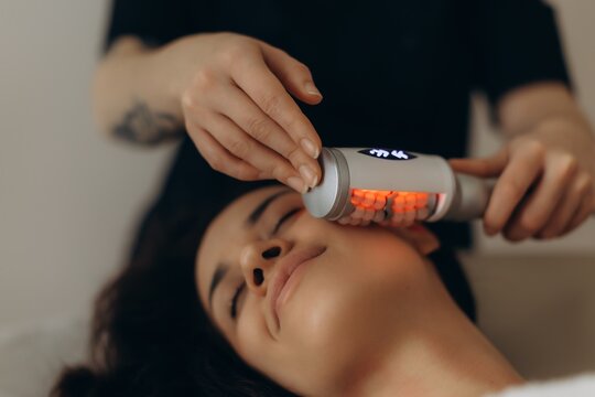Woman enjoying facial skincare treatment with modern device. endosphere facial therapy