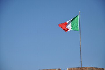 Waving flag of Italy against blue sky