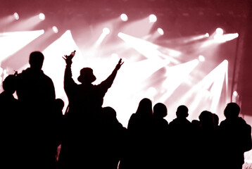 Fototapeta premium Crowd at a music concert, audience raising hands up silhouette