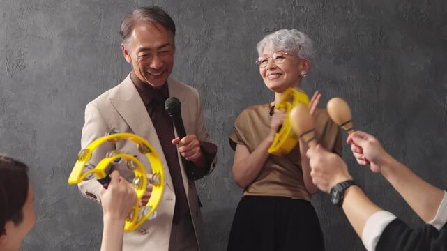 マイクを持って歌を歌うシニア男女　ライフスタイルイメージ